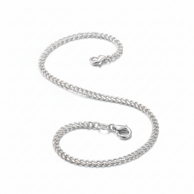 Silver chain bracelet on a soft pink fabric background