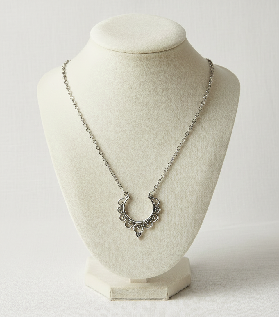 Silver necklace with a crescent moon pendant on a white mannequin bust.