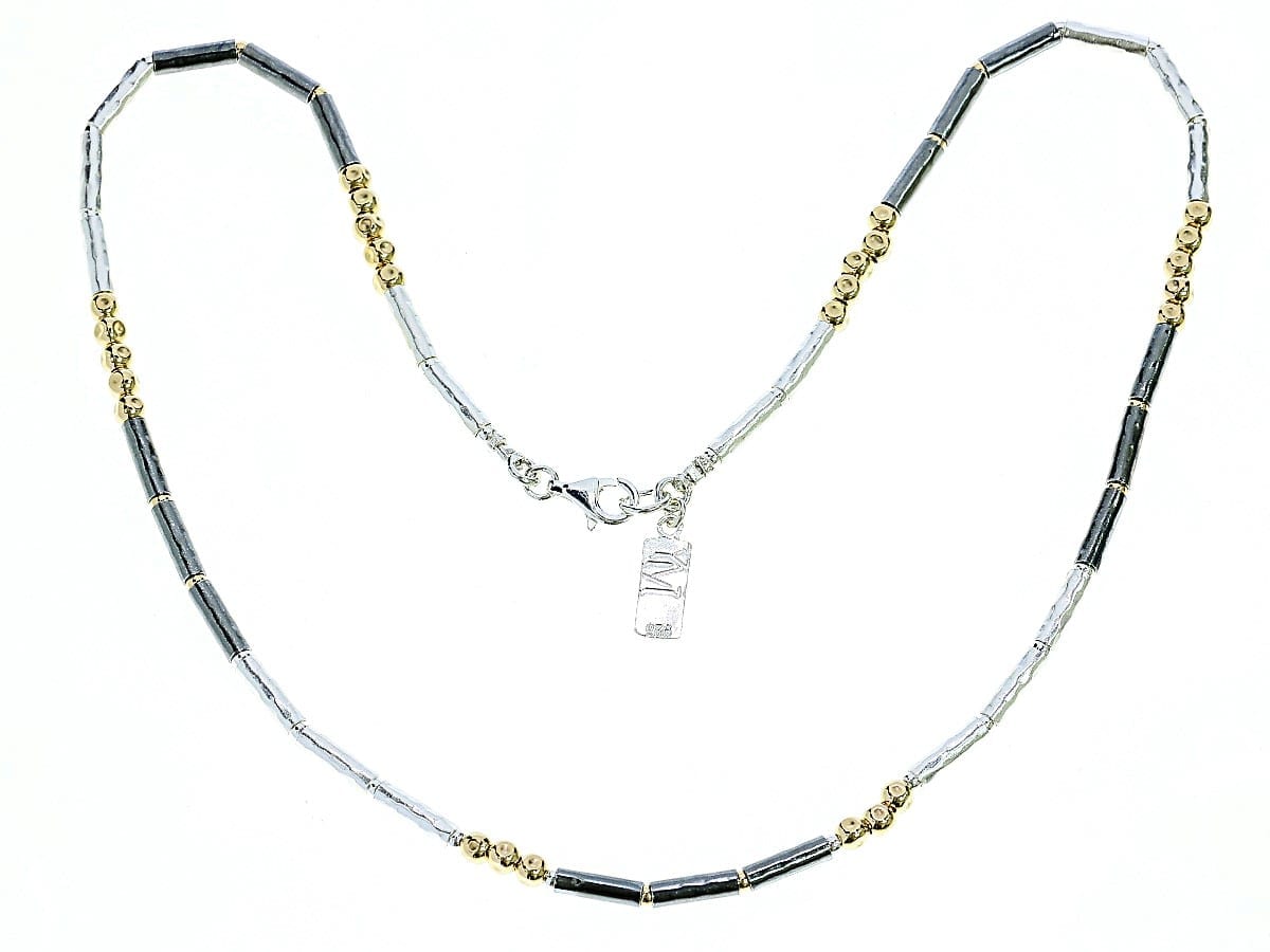 gold beads and silver and dark silver barrels necklace on a white background
