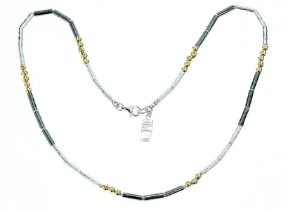 gold beads and silver and dark silver barrels necklace on a white background